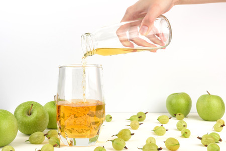 Pouring apple juice into the glass. Detox green Apple and gooseberry juice in a glass, healthy drinks conceptの写真素材