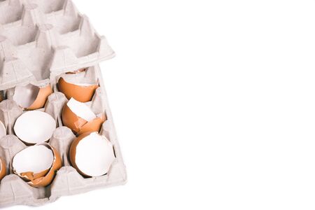 Egg shells in egg box. Close-up view of raw chicken eggs isolated on white background