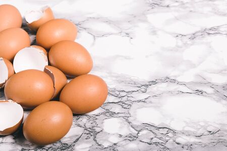 Egg shells on marbel table. Close-up view of raw chicken eggs on gray backgroundの写真素材