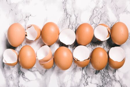 Egg shells on marbel table. Close-up view of raw chicken eggs on gray background