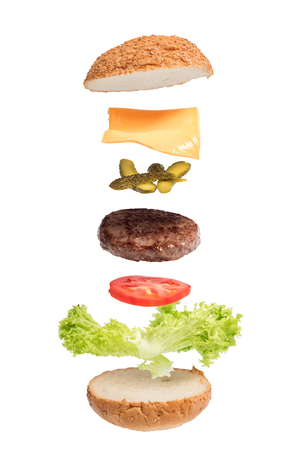 Big burger with flying ingredients. Delicious fresh cheeseburger isolated on white backgroundの写真素材