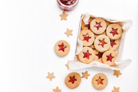 Cookies with raspberry jam on a table. Gingerbread in box on a white background. Star and round shapeの写真素材