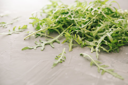 Fresh green arugula on a stone background. Garden rocket salad on a gray table.の写真素材
