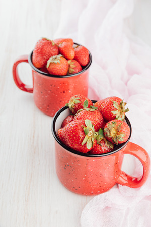 Fresh sweet berries in a red cup.の写真素材