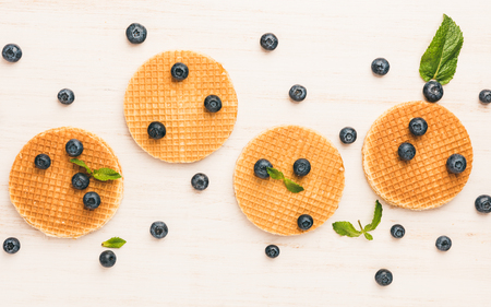Traditional belgian waffles with fresh blueberry on white wooden background. Flat lay, top view, copy space.の写真素材
