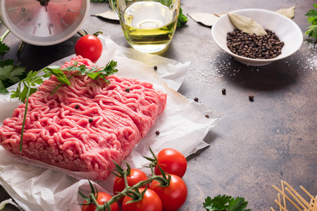 Raw fresh minced meat, red cherry tomatoes, bay leaf, salt and olive oil, green onions and spaghetti...