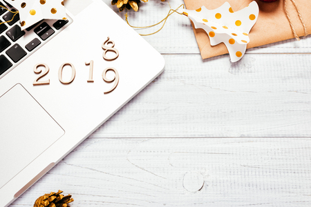 Laptop with Christmas decorations and gifts on wooden table. Christmas mock up template. Home office workspace. 2019 New Yearの写真素材