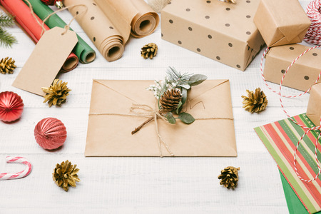 Christmas presents and gift boxes wrapped in kraft paper, envelope on a wooden table, fir-tree...