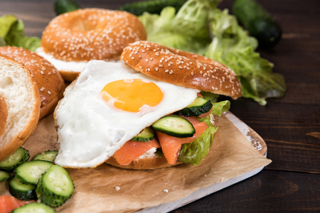 Fresh homemade bagel sandwiches with smoked salmon and low fat cream cheese and an egg.の写真素材