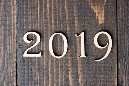 Carved wooden digits forming number 2019 on wooden background. New Year symbol, top viewの写真素材