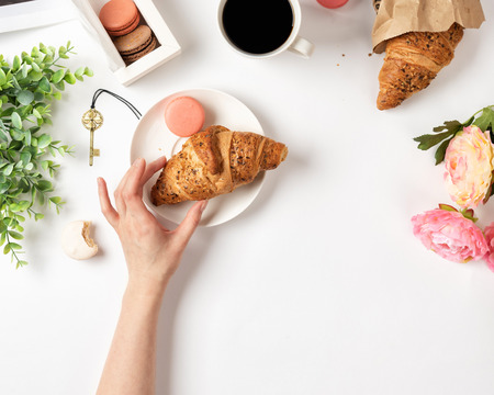 Woman's hand holding croissant.の写真素材