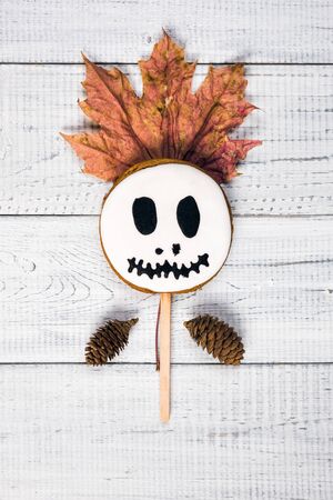Funny delicious ginger cookies for Halloween on the wooden table. Cake pops like ghost and pumpkin, top view, flat layの写真素材