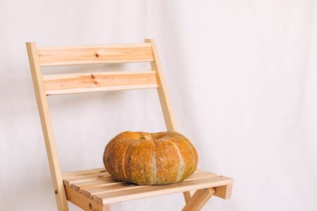 Pumpkin on a wooden stool, fabric backgroundの写真素材