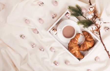 Morning breakfast on a wooden tray with a cup of coffee or cocoa croissant in bed. Hotel Room concept, copy space. Top view, flat layの写真素材