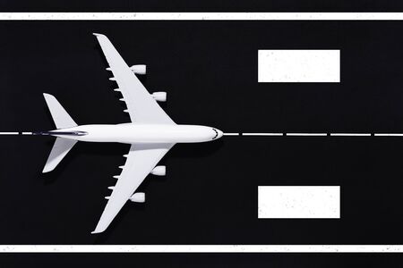 Model airplane on a black paper runway.の写真素材