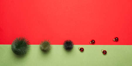 Christmas trees and ornaments on red and green paper background. Christmas or New Year festive...