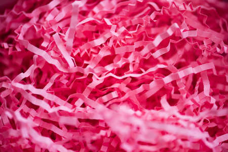 Texture of shredded pink paper packing material. Background for copy space