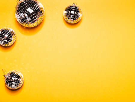 Mirror disco balls on yellow paper background.の写真素材