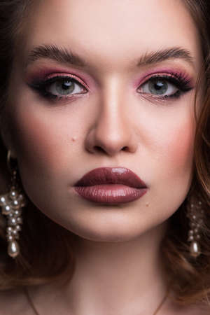 Portrait of a beautiful rich woman in jewelry necklace and earrings
