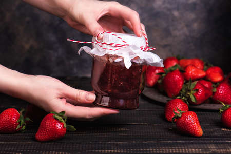 Woman holds a jar of strawberry jam
