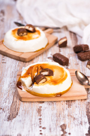 Vanilla panna cotta with caramel on wooden rustic tableの写真素材