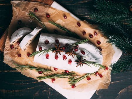 Christmas fruit cake with sugar powder on wooden board.
