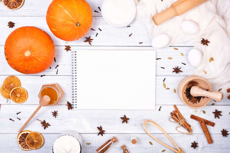 Book and Ingredients for pumpkin pie with cinnamon and pecan nutsの写真素材