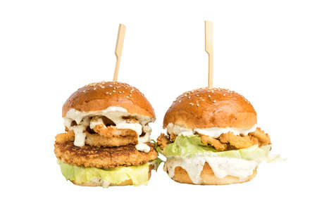 Fish burger with sauce and vegetables isolated on whiteの写真素材
