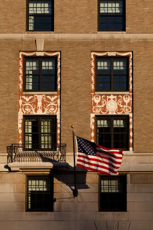 Detail of a building with windows and an American flagのeditorial素材