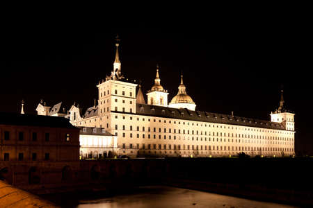 San Lorenzo de El Escorial Monastery  at night beautifully illuminated. Four towers are set off by black background.のeditorial素材