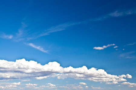 Blue summer sky with low white clouds with copy spaceの写真素材