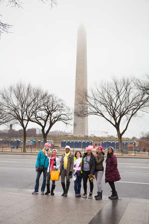 Group of women on Constitution Avenue with the Washington Monument bathed in fog in the background making their way to the rally to protest President Trump's positions on women's and other human rights.のeditorial素材