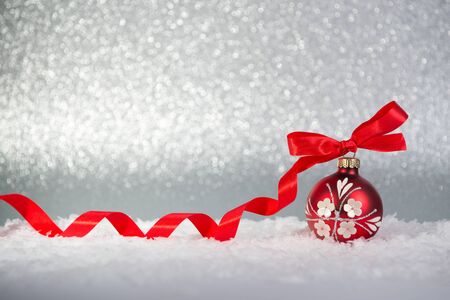 Christmas background, red ball with bow on a snowの写真素材