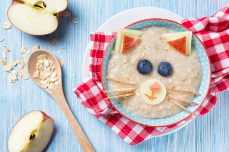 Funny oat porridge with cat, kitten face made of fruit and berries, food for kids idea, top viewの写真素材