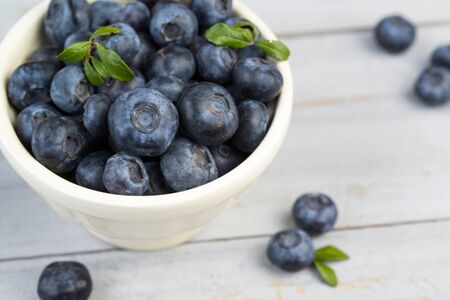 Bowl with fresh blueberries and leaves, closeupの写真素材