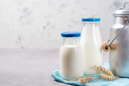 Bottles of fresh milk and aluminum milk can on a tableの写真素材
