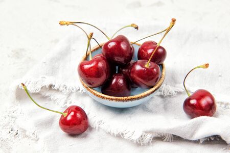 Bowl with ripe fresh red cherries on the tableの写真素材
