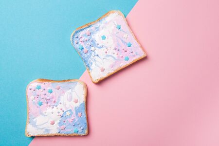 Unicorn or mermaid toasts with stars, food for kids idea, top view on a blue and pink backgroundの写真素材