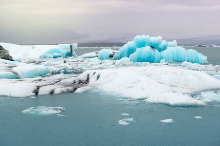 Floating icebergs and view to the glacier, ice lagoon Jokulsarlon, Iceland