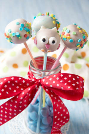 Owl cake pops with multi colored sprinkles in the bottle with blue smarties, sweet food for kidsの写真素材