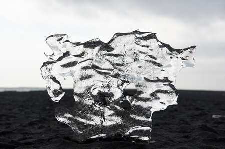 Transparent ice floe on the black sand beach, Iceland, Jokulsarlon lagoon