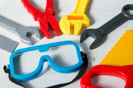 Colorful set of plastic toy tools for children on a wooden backgroundの写真素材