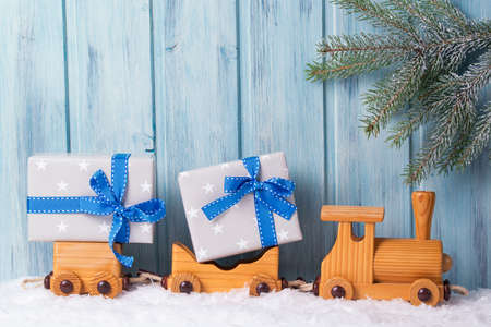 Old wooden toy train with Christmas gifts, wooden backgroundの写真素材