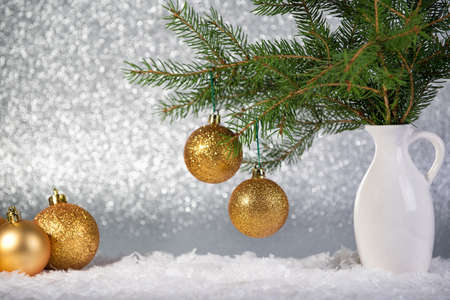 Christmas background with fir tree branches in the vase and golden ballsの写真素材