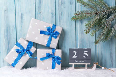 Christmas block calendar with 25 December and gift boxes, wooden background with fir tree branchの写真素材