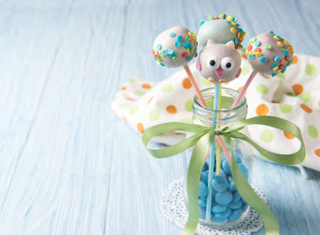 Owl cake pops with multi colored sprinkles in the bottle with blue smarties, sweet food for kidsの写真素材