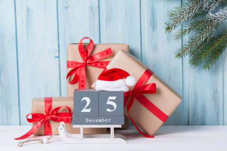 Christmas block calendar with 25 December and gift boxes, wooden background with fir tree branchの写真素材