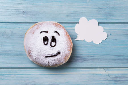 Donut with smiley face and text cloud, wooden backgroundの写真素材