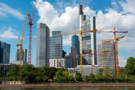 FRANKFURT, GERMANY - May 14, 2014: Frankfurt Skyline with construction cranes by Main River. Frankfurt is the financial center of Germany.のeditorial素材