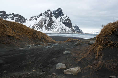 Stokksnes Peninsula, Vestrahorn mountains and black sand dunes over the ocean, winter landscape, Icelandの写真素材